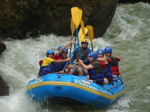 Persona disfrutando de rápidos en un río de montaña